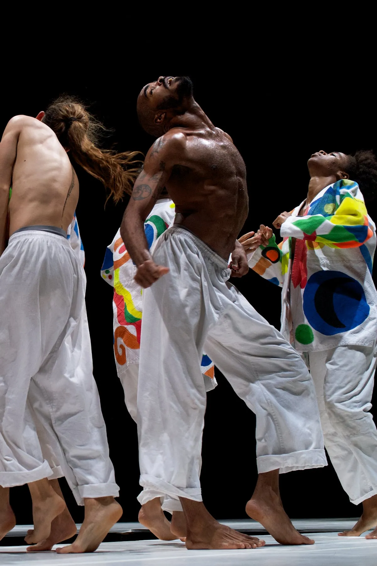 Danseurs cubains vêtus de kimonos colorés interprétant une pièce de danse contemporaine Brutal chorégraphiée par Nelson Reguera